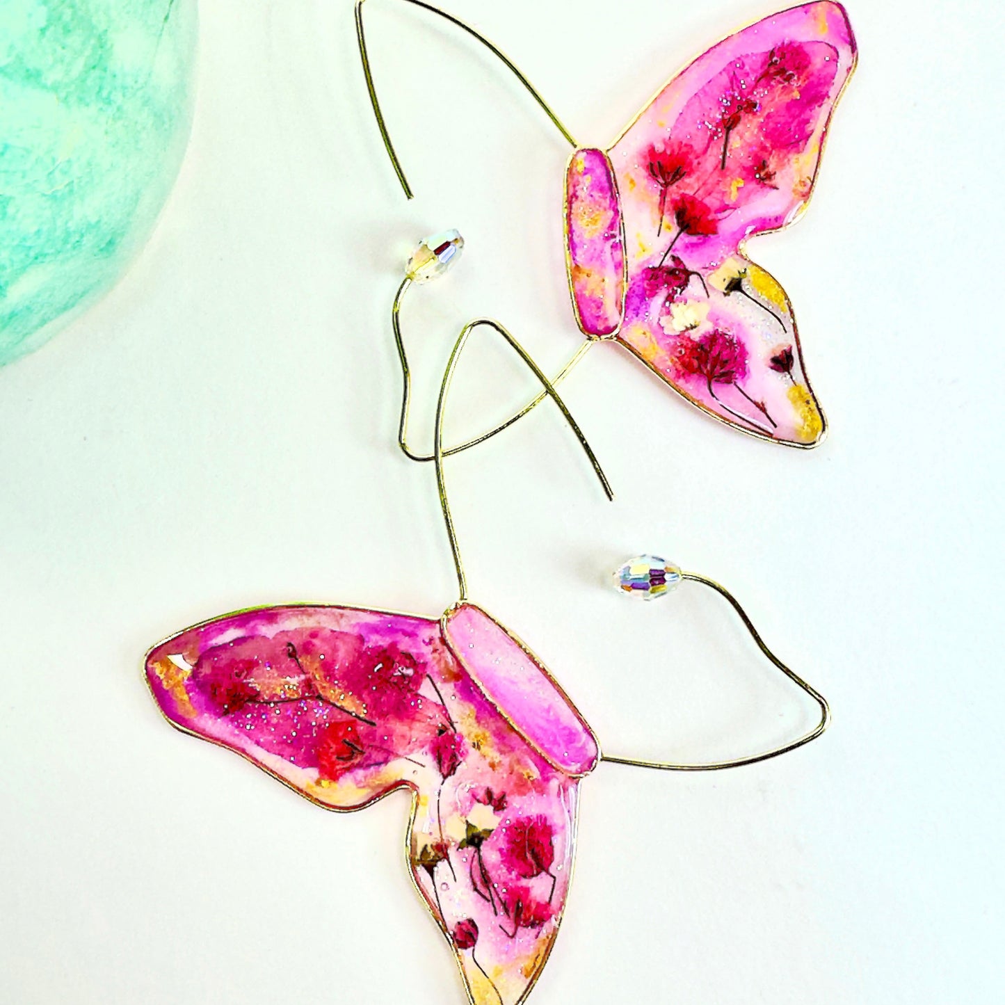 Pressed flower butterfly earrings featuring local dried flowers and austrian crystal accents. Handmade in Texas by Chestnut Chic Studio.