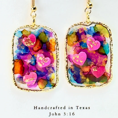 Multi colored 3D heart earrings with resin and clay on white card.