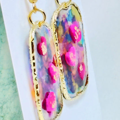 Multi colored 3D heart earrings with resin and clay on white card.