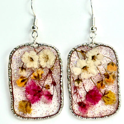 pressed flower earrings with mini buds in pink, yellow and white. Shimmering in a silver-tone setting. Make in Texas.