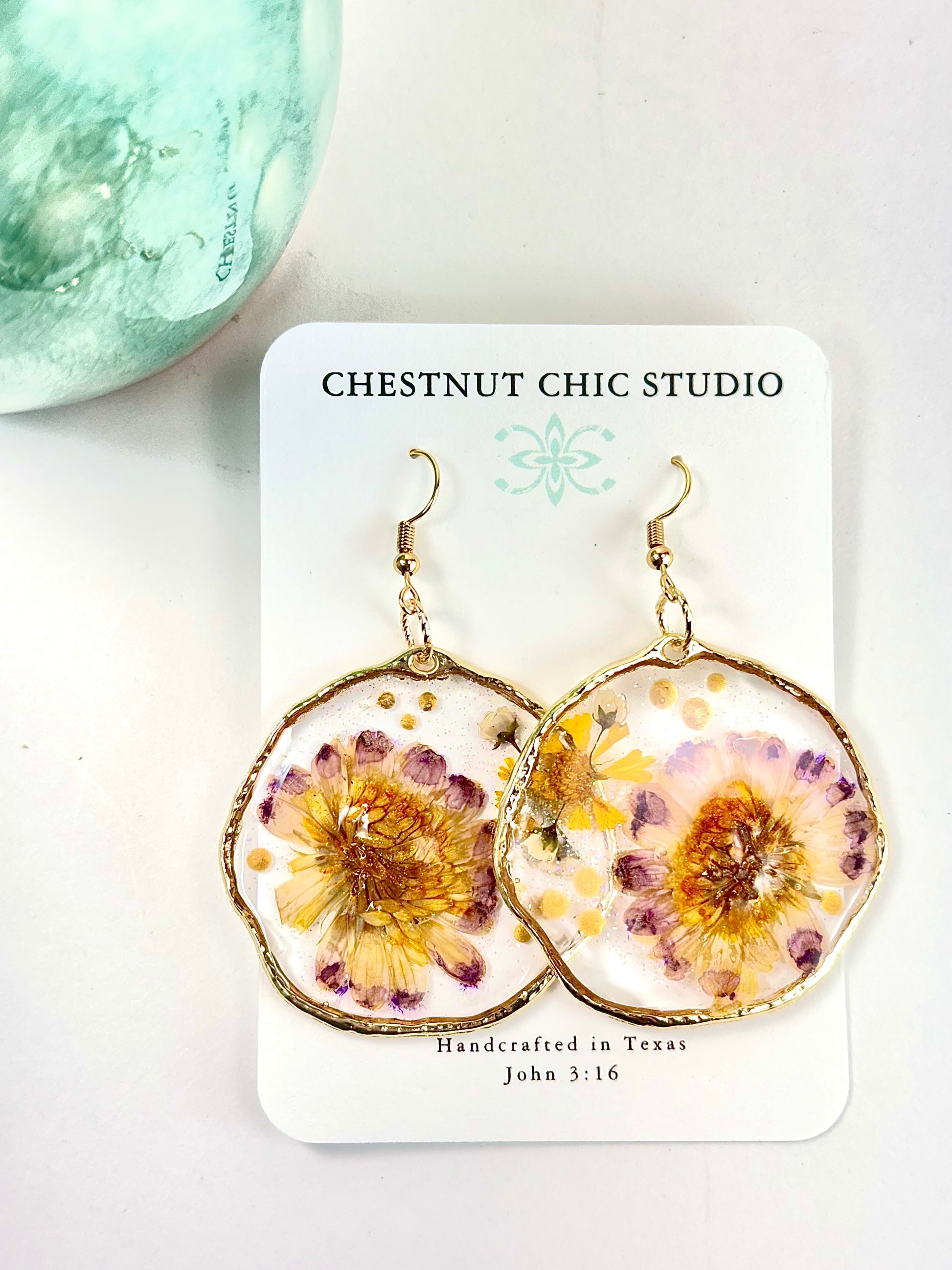 Yellow and purple daisy pressed flower earrings in gold hoop setting
