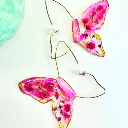 Pressed flower butterfly earrings featuring local dried flowers and austrian crystal accents. Handmade in Texas by Chestnut Chic Studio.