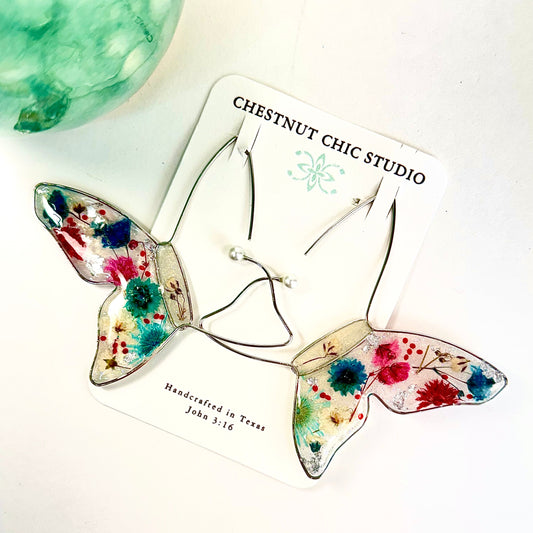 Hand crafted floating butterfly earrings with red, white and blue pressed flowers. Perfect for July 4th. Chestnut Chic Studio
