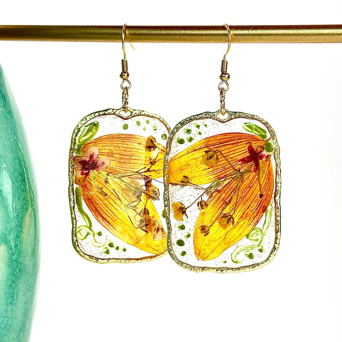 pressed locally sourced sunflower petal earrings set in a gold rectangular hoop