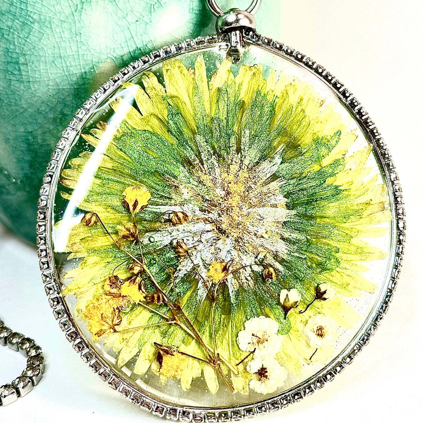 This one-of-a-kind artisan necklace features a green Dahlia with white and yellow mini flowers set in a clear sparkling crystal bezel. Chestnut Chic Studio.