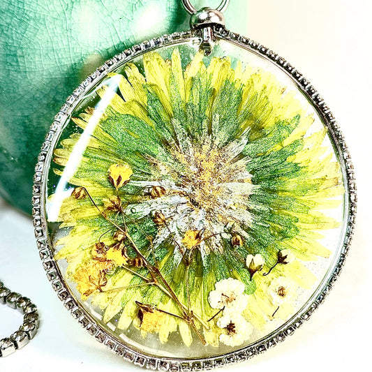 This one-of-a-kind artisan necklace features a green Dahlia with white and yellow mini flowers set in a clear sparkling crystal bezel. Chestnut Chic Studio.