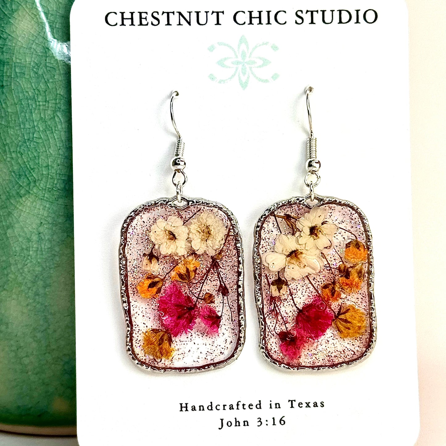 pressed flower earrings with mini buds in pink, yellow and white. Shimmering in a silver-tone setting. Make in Texas.