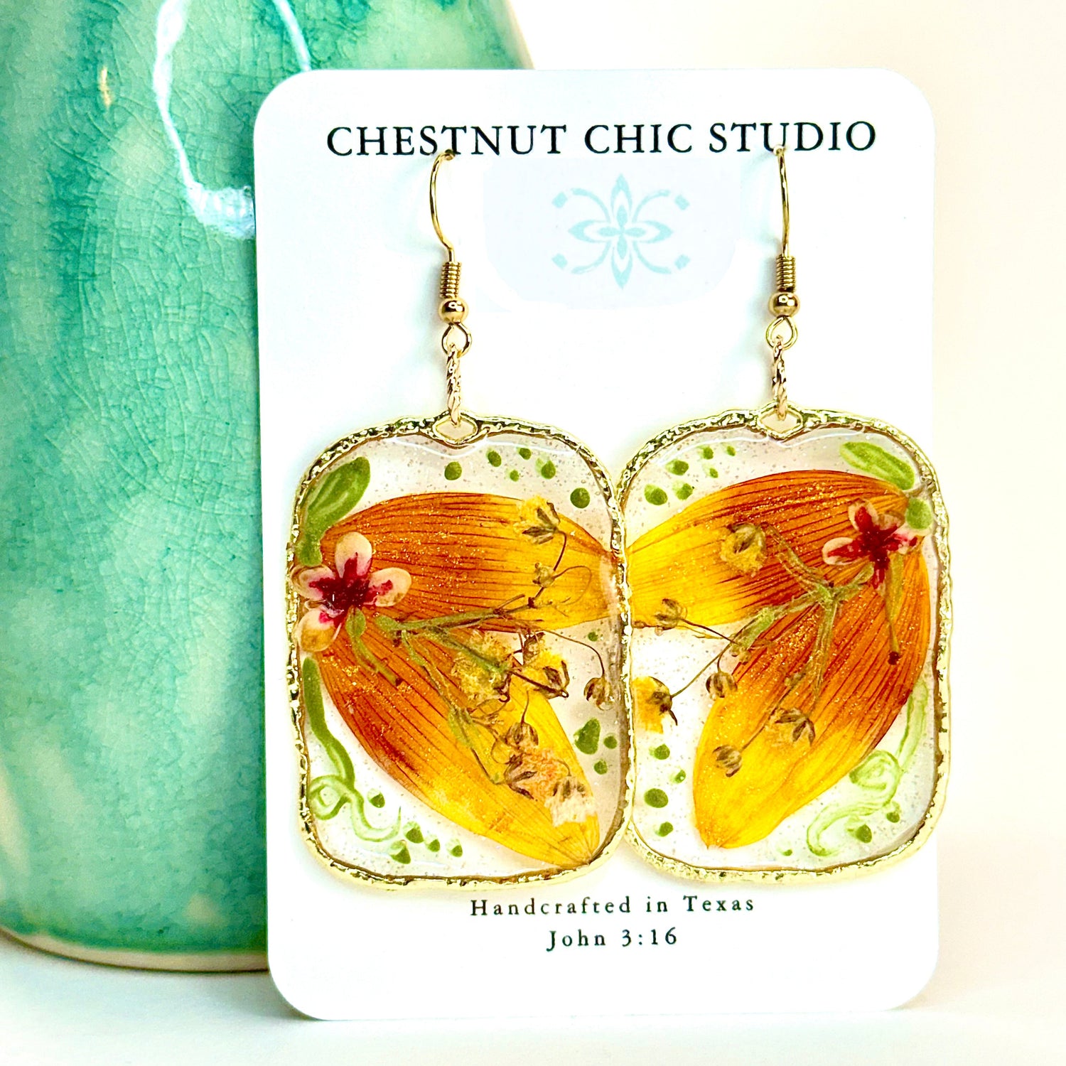 pressed locally sourced sunflower petal earrings set in a gold rectangular hoop