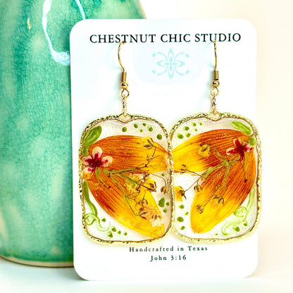 pressed locally sourced sunflower petal earrings set in a gold rectangular hoop