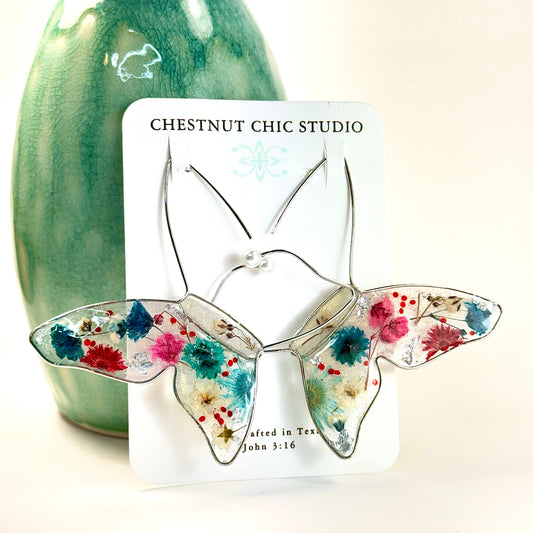 Floating butterfly earrings with red, white and blue Texas pressed flowers. Made in Texas USA by Chestnut Chic Studio 
