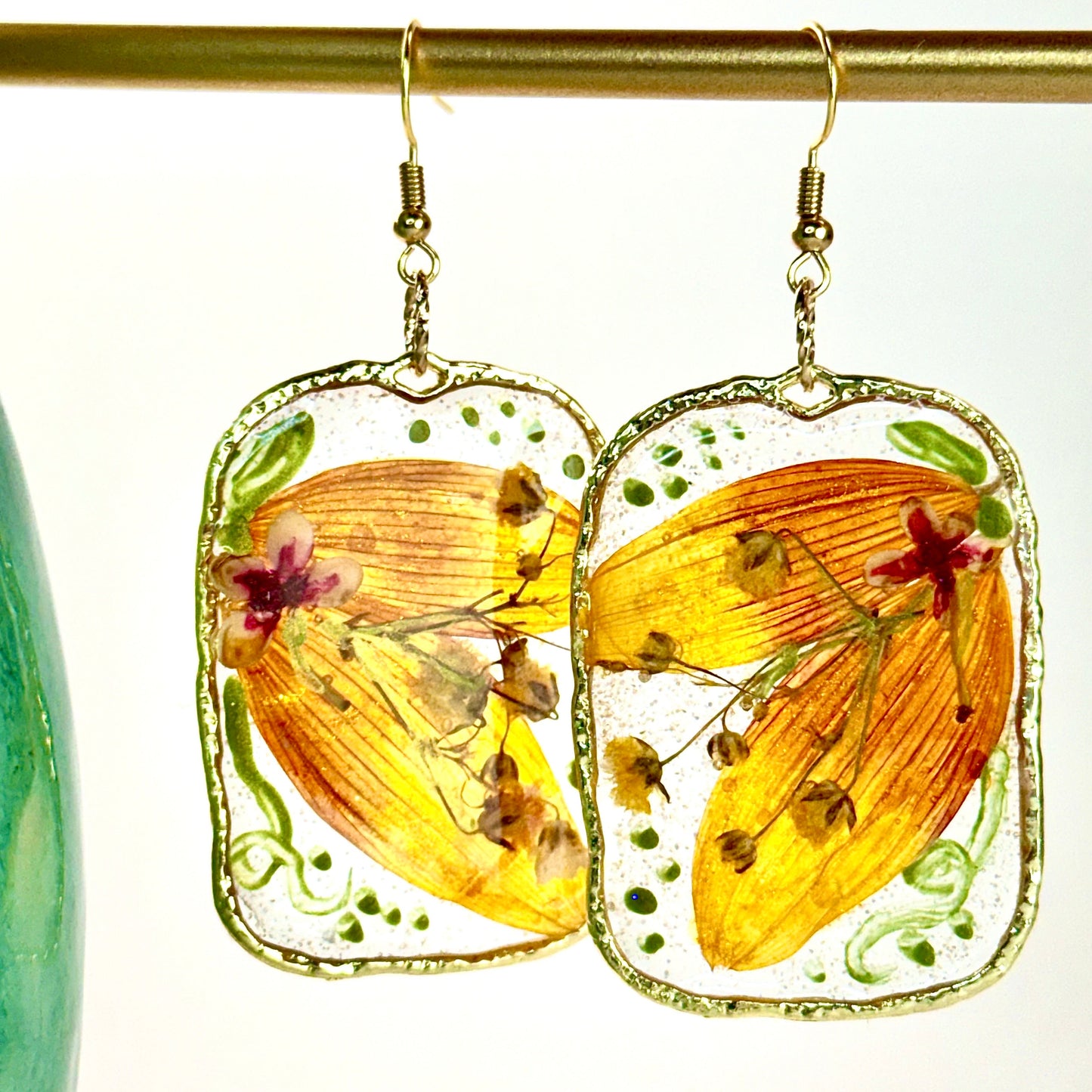 pressed locally sourced sunflower petal earrings set in a gold rectangular hoop